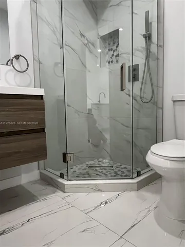a bathroom with a shower a toilet and a sink