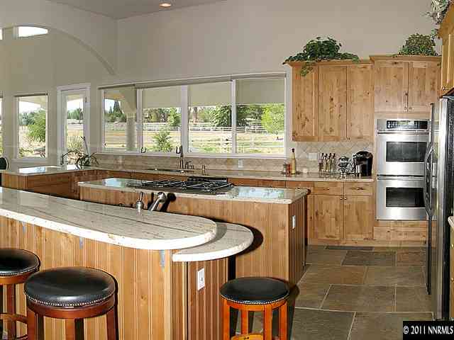 300 Vera Drive Reno, NV 89511 - Photo 7 of 13 a kitchen with stainless steel appliances a sink a table and chairs in it