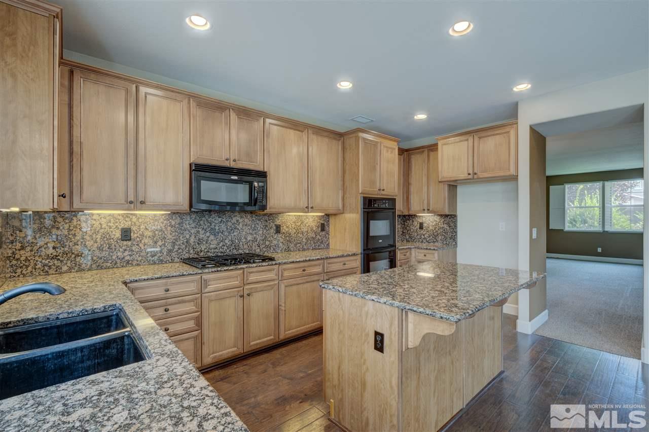 11105 Parma Way Reno, NV 89521 - Photo 7 of 32 a kitchen with stainless steel appliances granite countertop a sink stove and refrigerator
