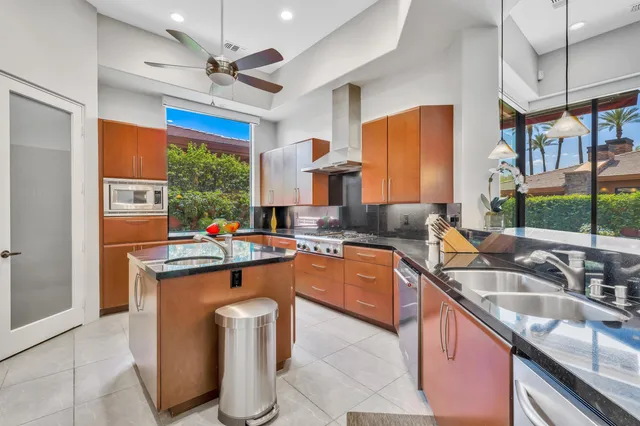 a kitchen with stainless steel appliances granite countertop a sink a stove and a refrigerator