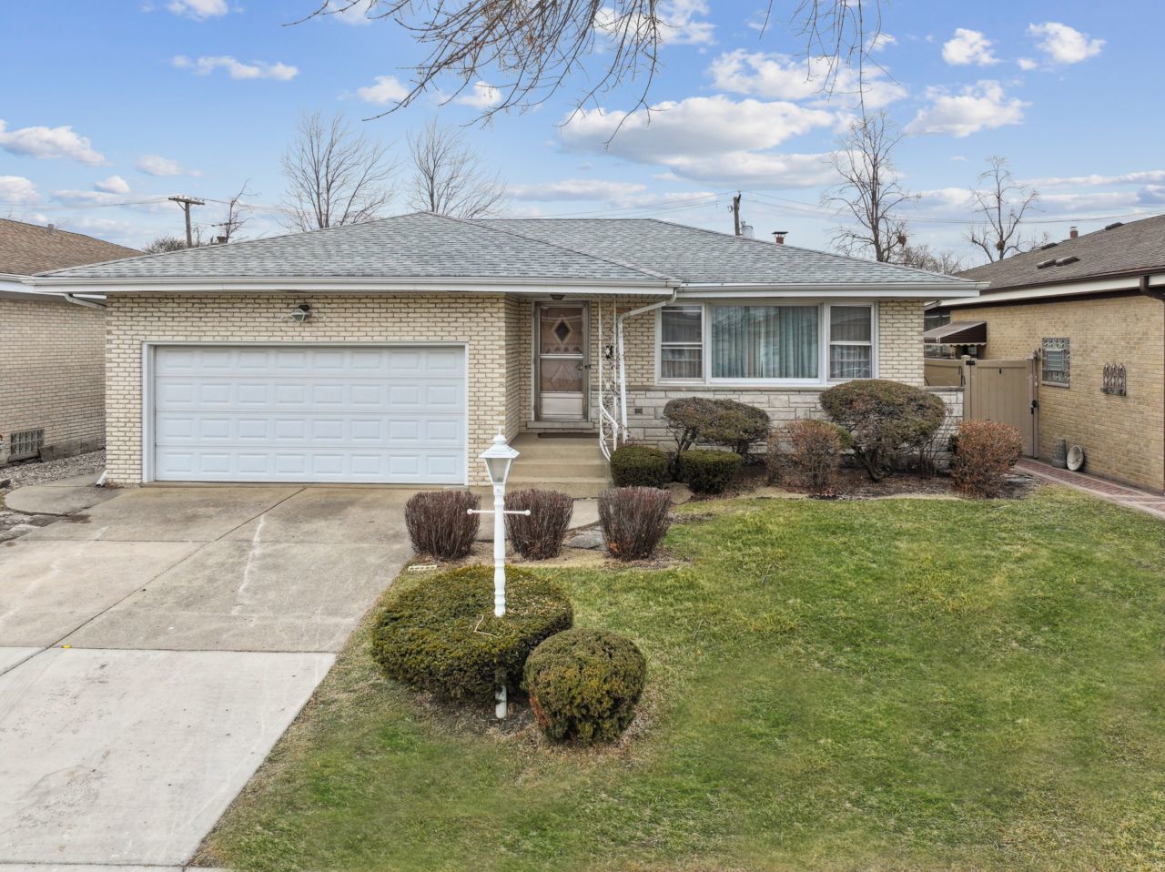 a front view of a house with a garden and parking space