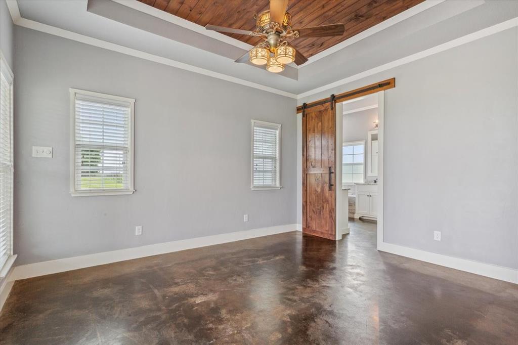 259 County Road 149 Riesel, TX 76682 - Photo 17 of 40 Spare room with a raised ceiling, concrete flooring, a ceiling fan, wooden ceiling, and plenty of natural light