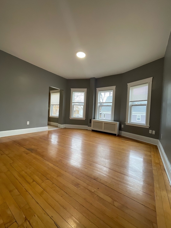 9 Page Street, Unit 2 Boston, MA 02121 - Photo 3 of 6 a view of an empty room with window and wooden floor