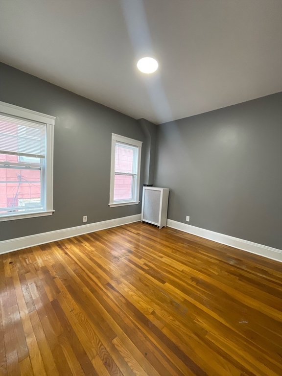 9 Page Street, Unit 2 Boston, MA 02121 - Photo 4 of 6 a view of empty room with wooden floor and fan