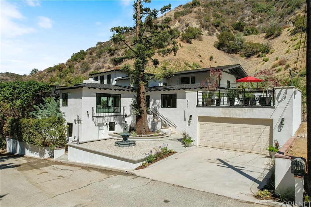 431 Nesmuth Road Glendale, CA 91202 - Photo 2 of 68 a view of a white house with large windows and a small yard