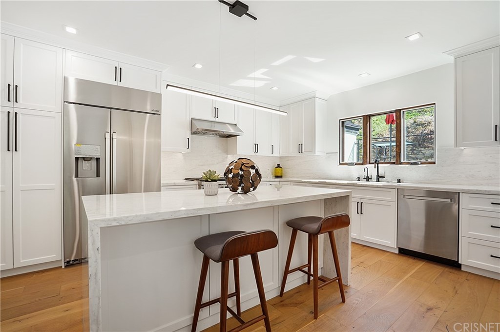 431 Nesmuth Road Glendale, CA 91202 - Photo 6 of 68 a kitchen with white cabinets stainless steel appliances and a center island