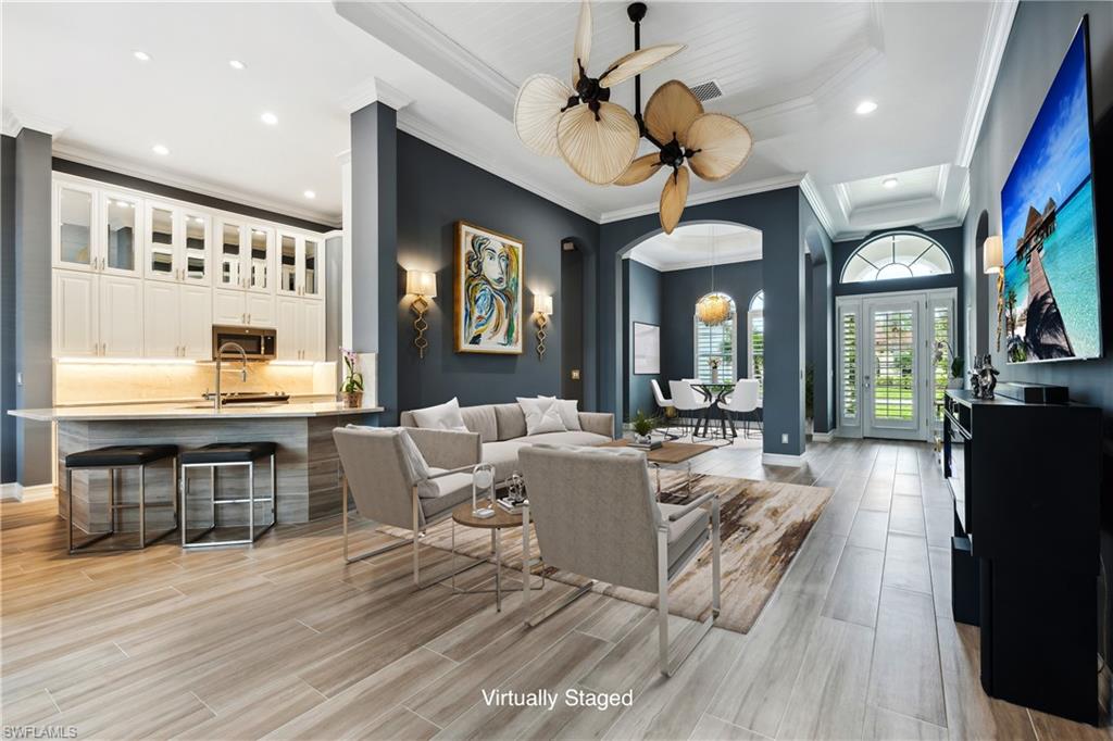 a living room with furniture a chandelier and a flat screen tv