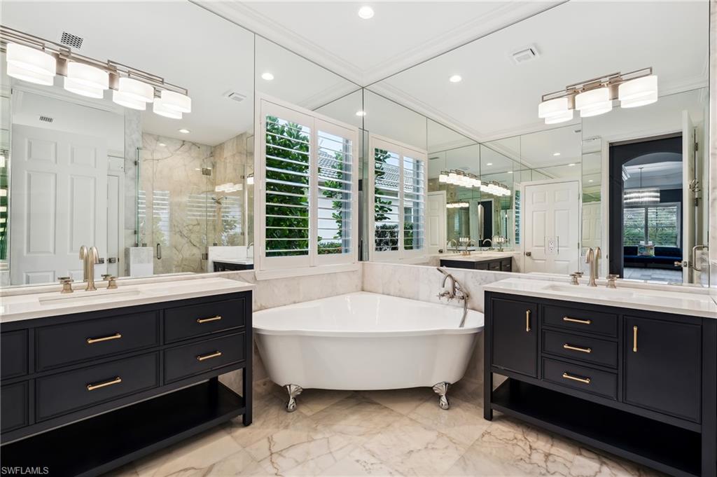 8239 Potomac Lane Naples, FL 34104 - Photo 14 of 47 a large tub sitting next to a bathroom sink and a window