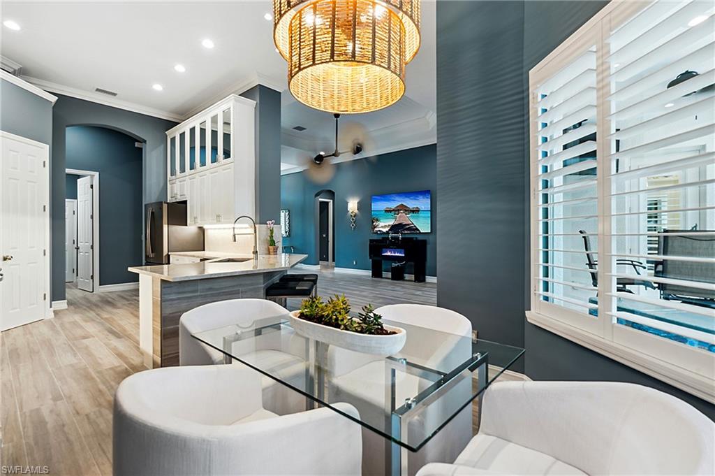 8239 Potomac Lane Naples, FL 34104 - Photo 16 of 47 a dining room with furniture and a chandelier