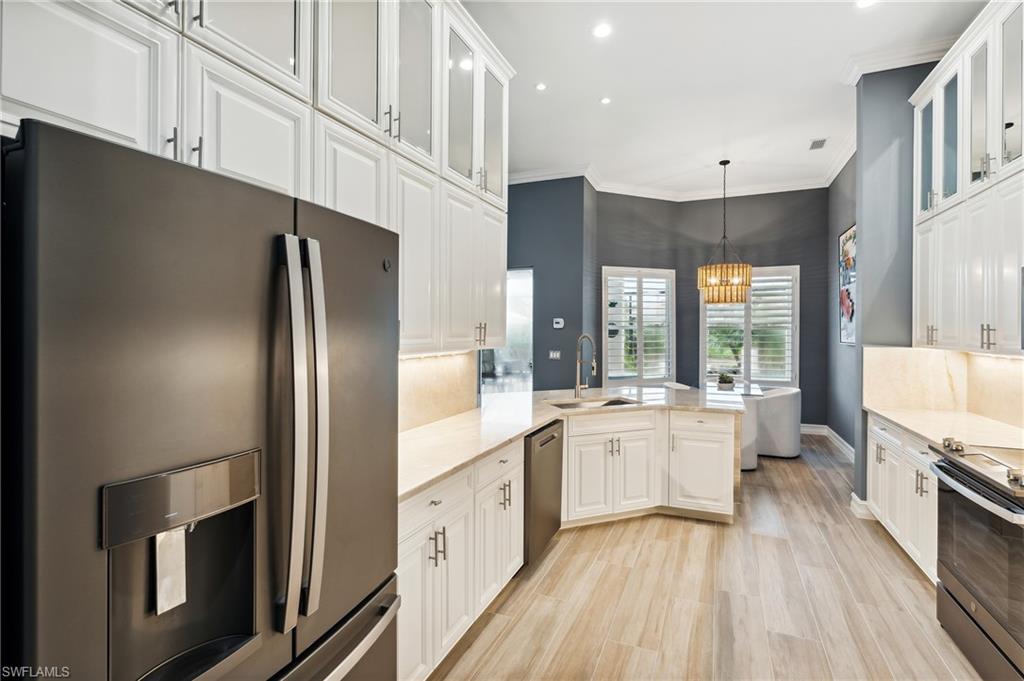 8239 Potomac Lane Naples, FL 34104 - Photo 18 of 47 a large kitchen with a large window a sink and stainless steel appliances