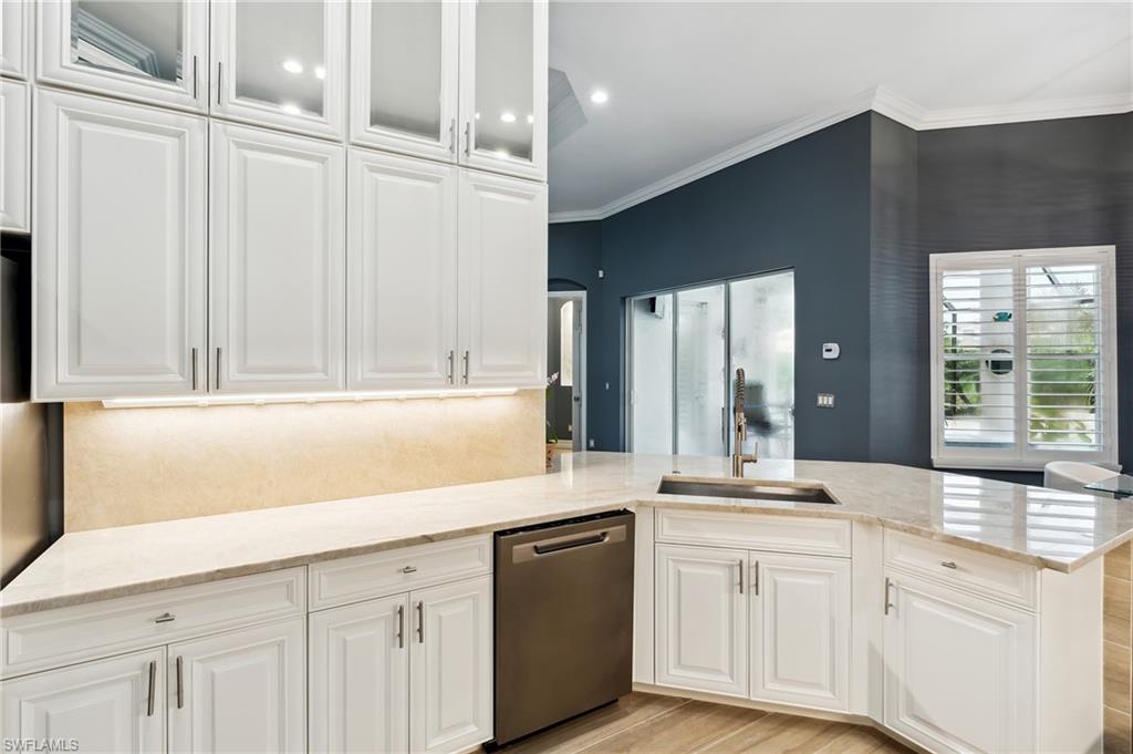 8239 Potomac Lane Naples, FL 34104 - Photo 19 of 47 a kitchen with white cabinets and a sink