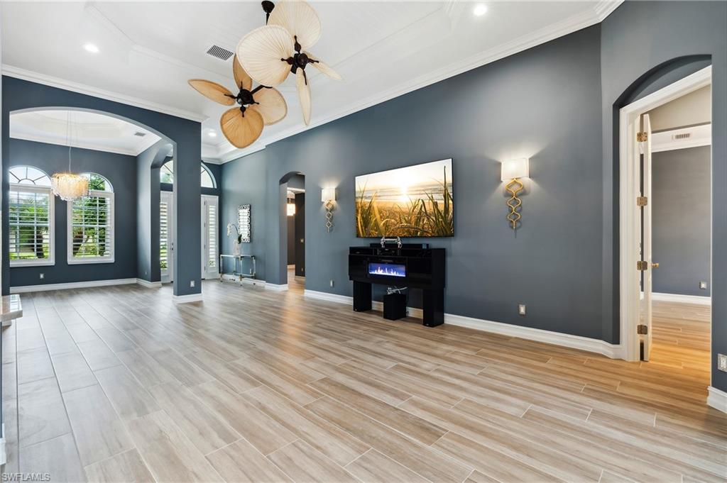 8239 Potomac Lane Naples, FL 34104 - Photo 25 of 47 a view of a livingroom with wooden floor and a ceiling fan