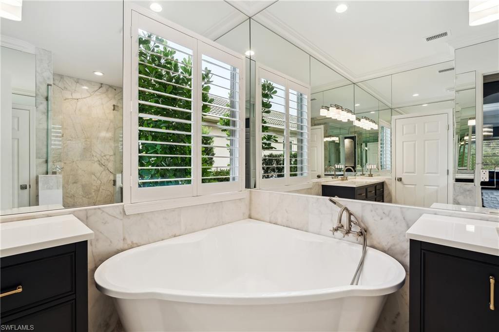 8239 Potomac Lane Naples, FL 34104 - Photo 31 of 47 a large white tub sitting in a bathroom and a sink