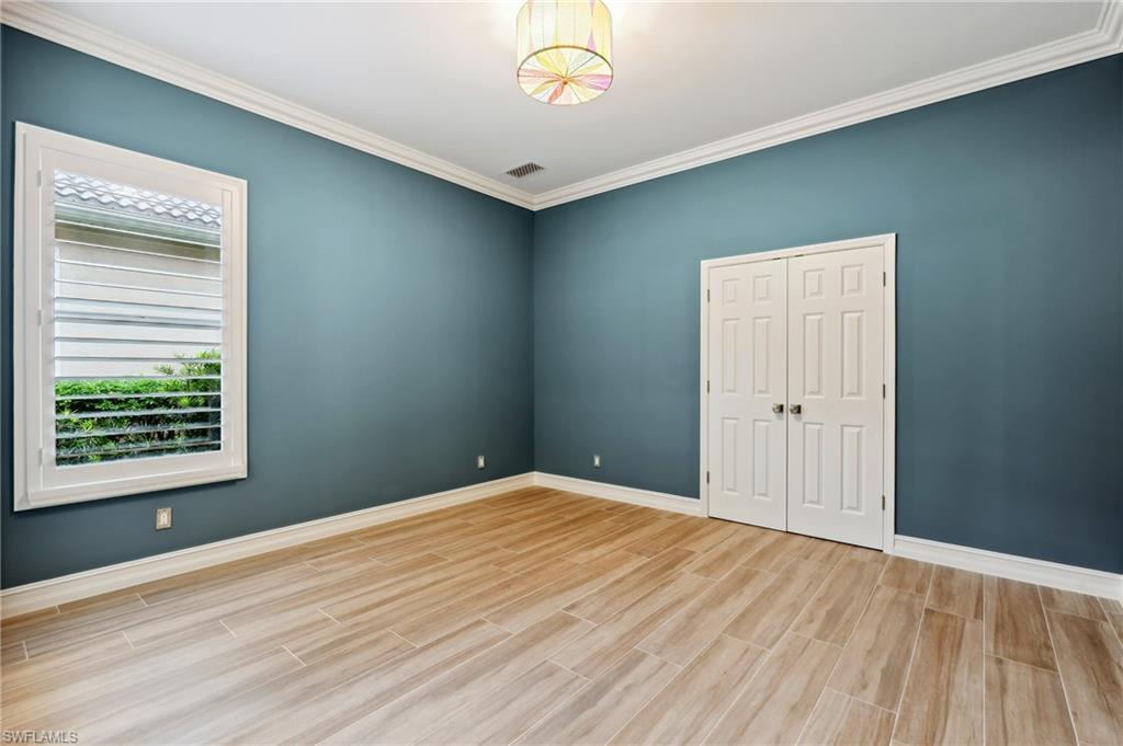 8239 Potomac Lane Naples, FL 34104 - Photo 35 of 47 a view of an empty room with wooden floor and a window