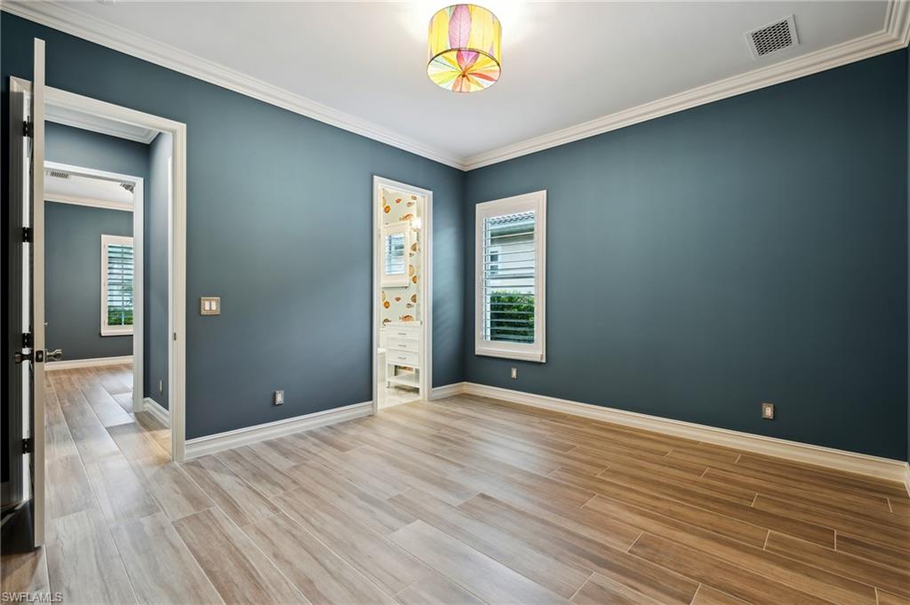 8239 Potomac Lane Naples, FL 34104 - Photo 36 of 47 a view of an empty room with window and wooden floor