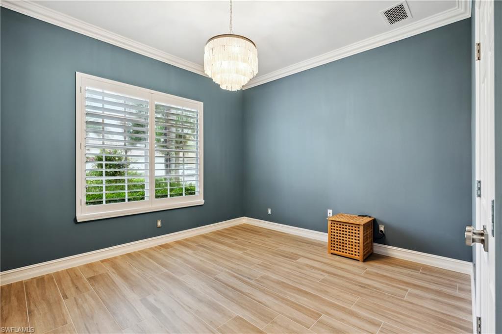 8239 Potomac Lane Naples, FL 34104 - Photo 38 of 47 a view of an empty room with wooden floor and a window