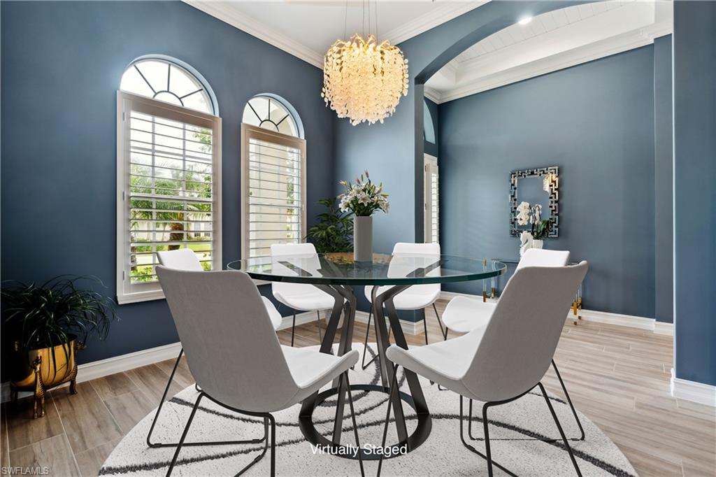 8239 Potomac Lane Naples, FL 34104 - Photo 7 of 47 a dining room with furniture potted plants and wooden floor