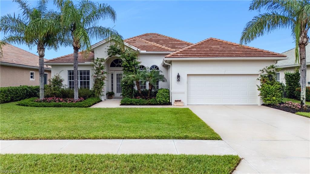 8239 Potomac Lane Naples, FL 34104 - Photo 9 of 47 a front view of a house with a garden and palm trees