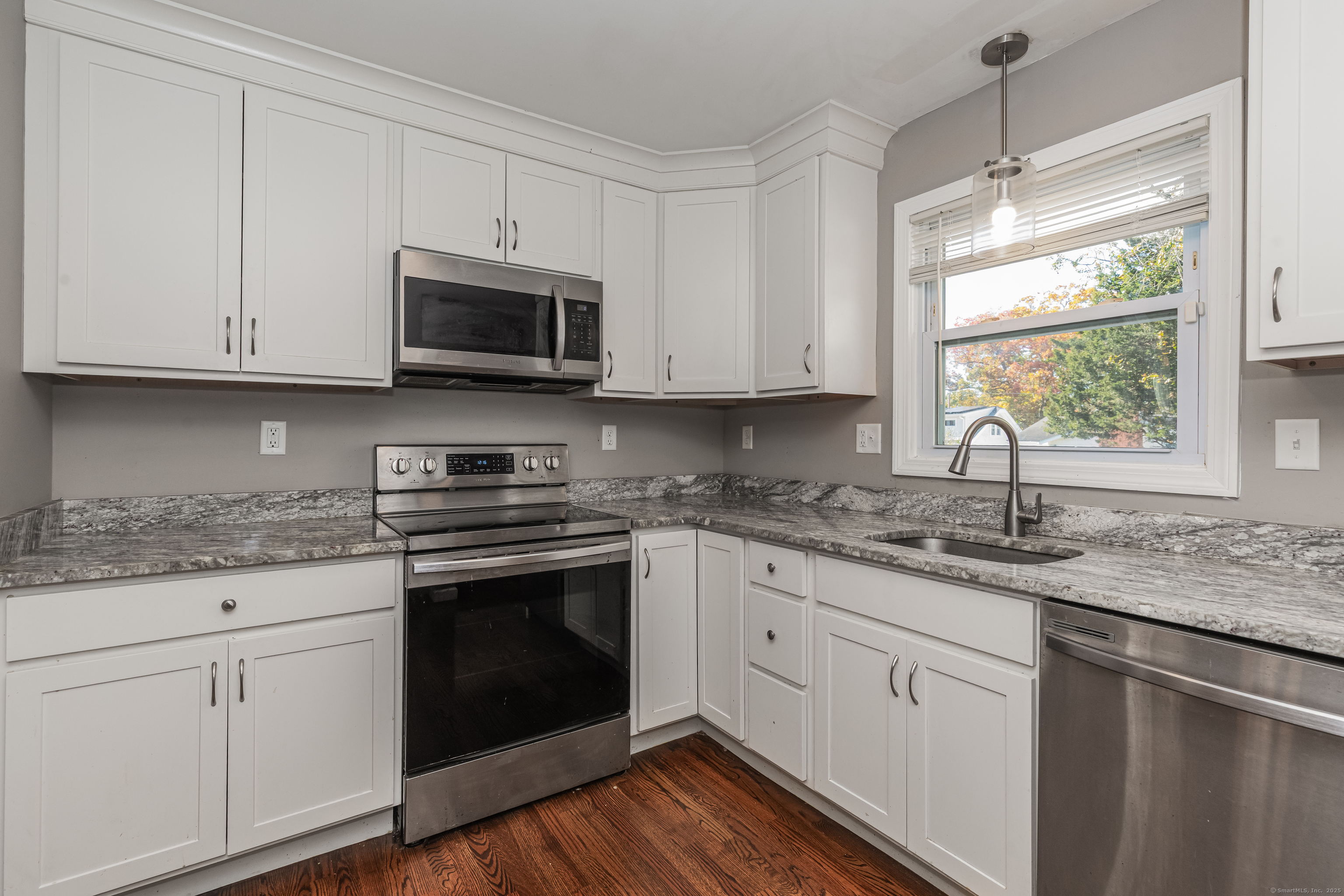 148 Central Avenue West Haven, CT 06516 - Photo 3 of 26 a kitchen with granite countertop white cabinets white appliances and a sink