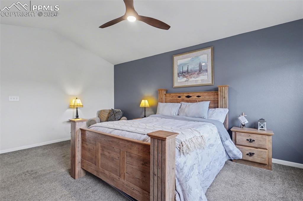 17063 Blue Mist Grove Monument, CO 80132 - Photo 15 of 33 a bedroom with a bed and a lamp on dresser