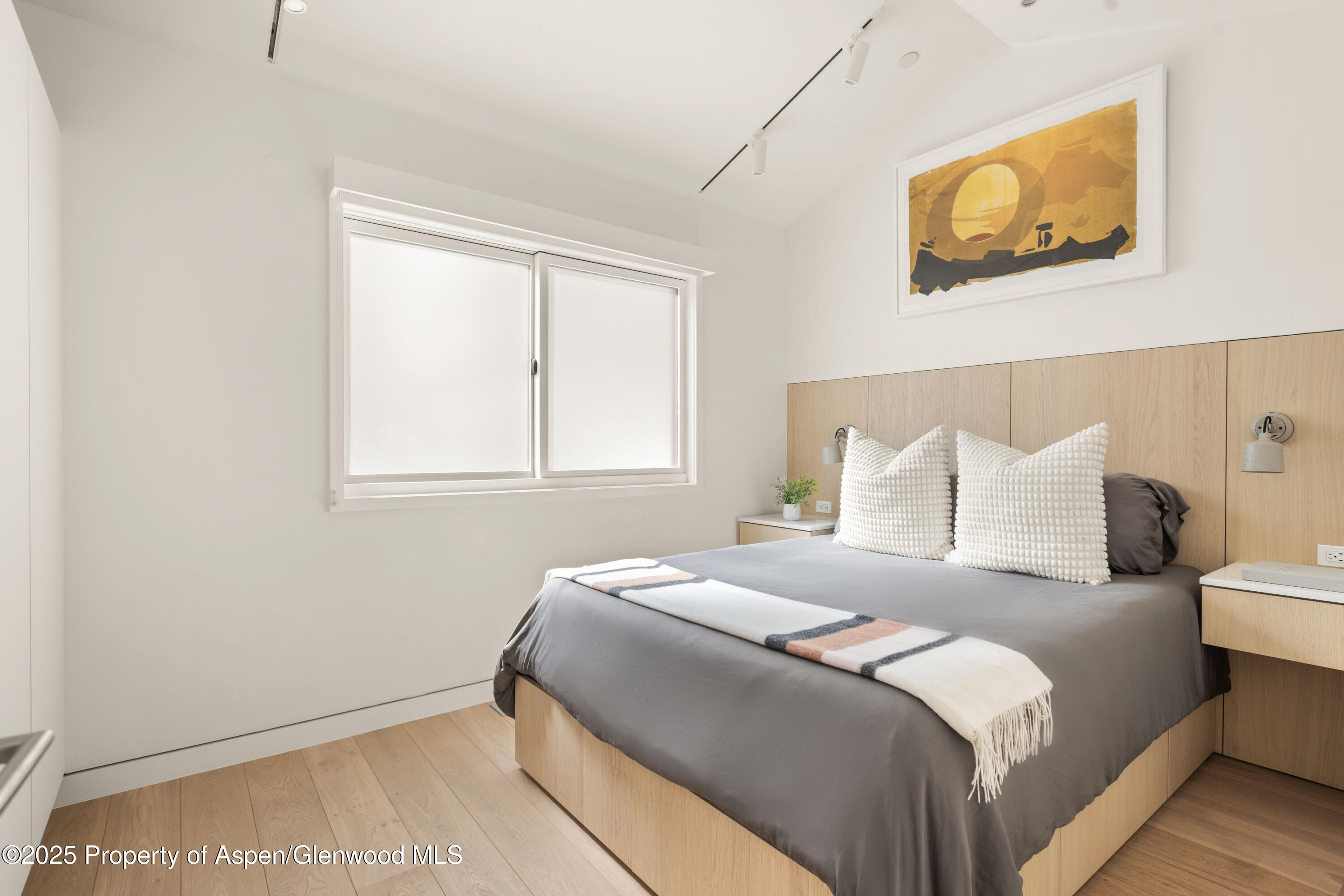 211 West Main Street, Unit 103 Aspen, CO 81611 - Photo 3 of 4 a bedroom with a bed and wall painting