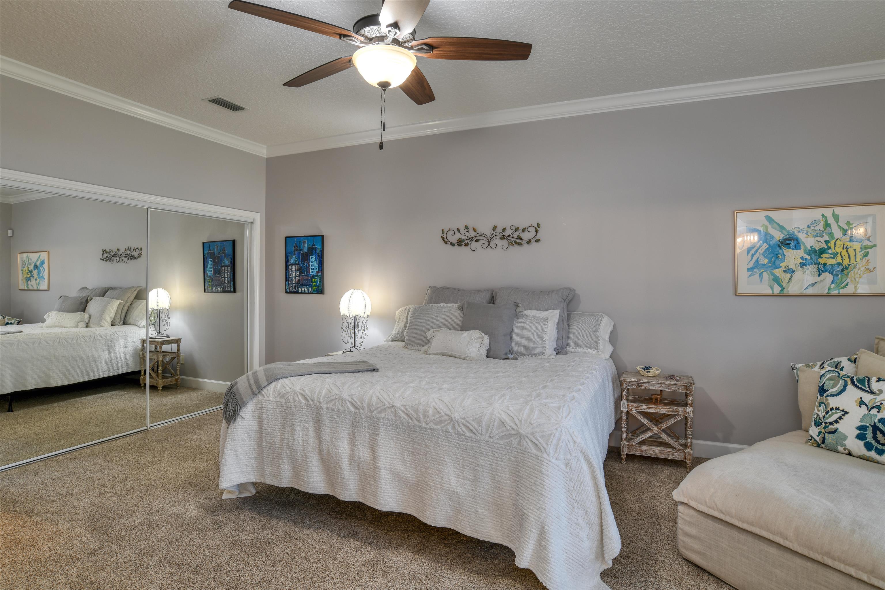 616 Mediterranean Way St. Augustine, FL 32080 - Photo 13 of 64 a bedroom with a bed and a chandelier