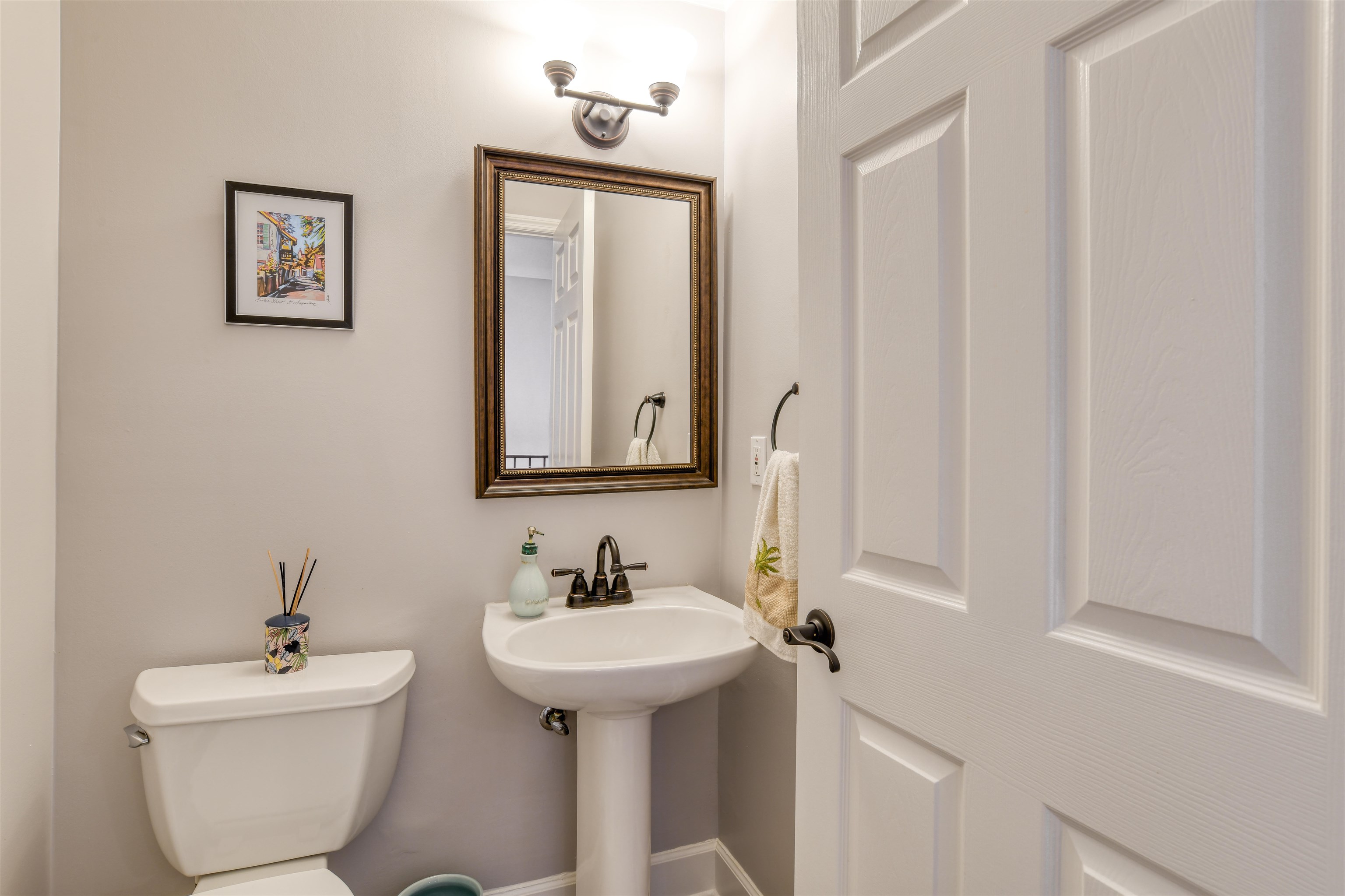 616 Mediterranean Way St. Augustine, FL 32080 - Photo 30 of 64 a bathroom with a toilet sink and mirror