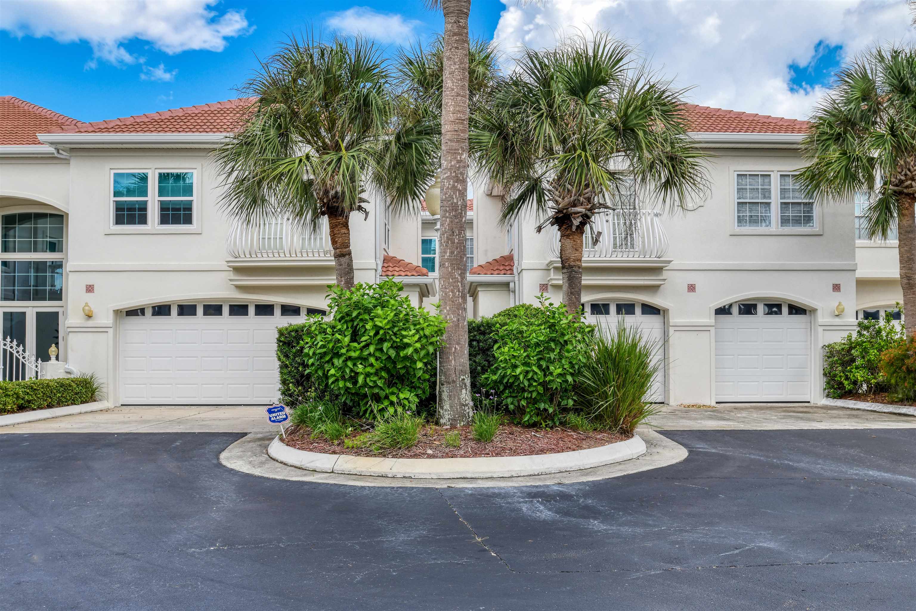 616 Mediterranean Way St. Augustine, FL 32080 - Photo 55 of 64 a view of a white house with a small yard and palm trees