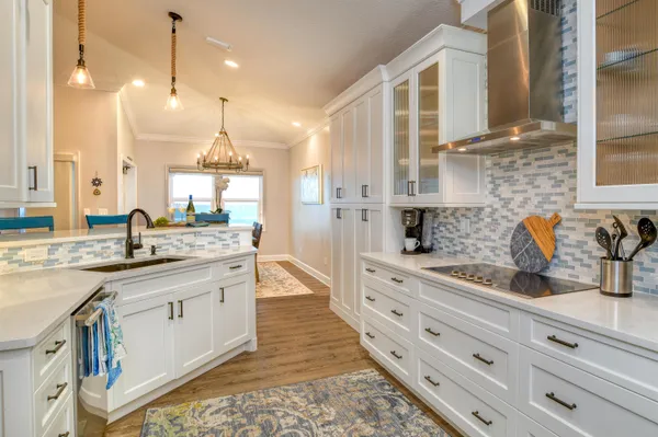 a large kitchen with granite countertop a sink a stove and cabinets