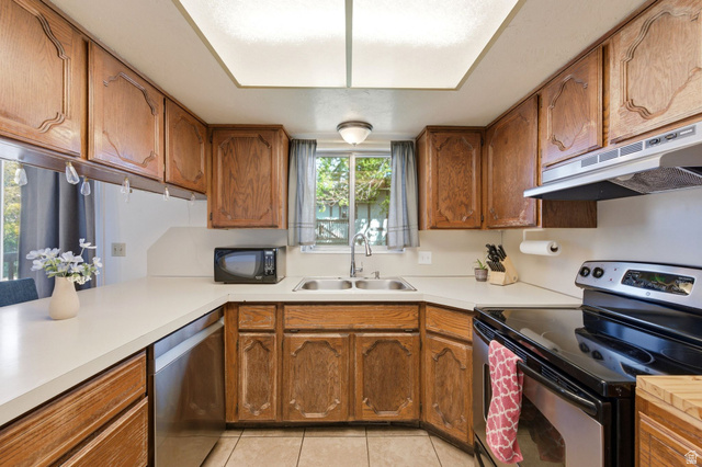 2632 North 140 West Sunset, UT 84015 - Photo 4 of 12 Kitchen featuring stainless steel appliances, wood finish cabinetry, light countertops, and light tile patterned floors