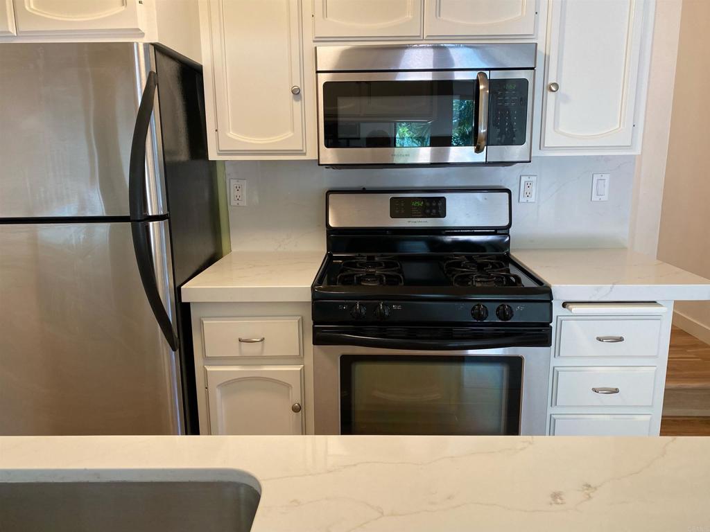 a kitchen with stainless steel appliances wooden cabinets and a stove