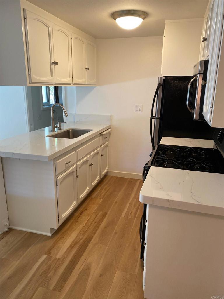 714 Passiflora Avenue, Unit 1 Encinitas, CA 92024 - Photo 3 of 14 a kitchen with a refrigerator and a sink