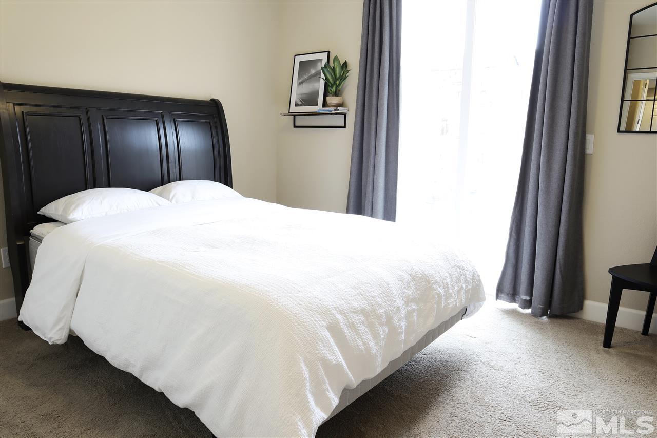10060 Barrel Racer Drive Reno, NV 89521 - Photo 12 of 13 a large bed sitting in a bedroom next to a wooden closet