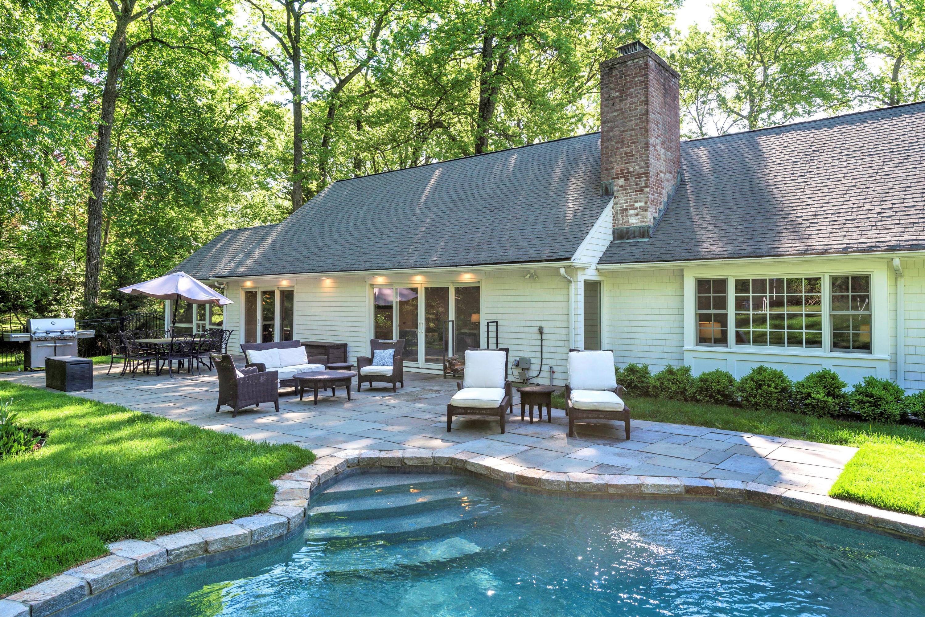a view of a house with swimming pool and sitting area