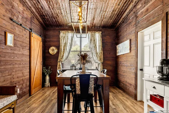 a dining room with furniture a floor to ceiling window and potted plants