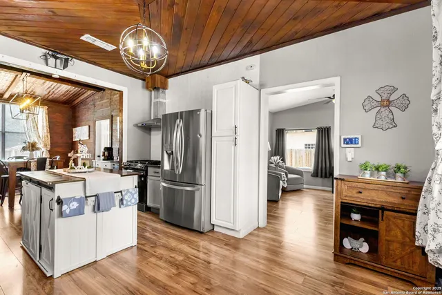 a kitchen with stainless steel appliances granite countertop a refrigerator a stove top oven a sink and dishwasher