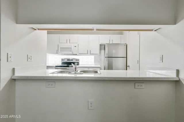 a kitchen with kitchen island a sink a stove and white cabinets