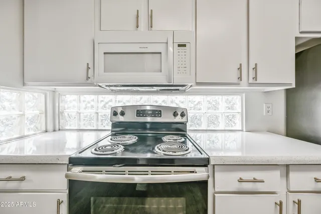 a stove top oven sitting inside of a kitchen