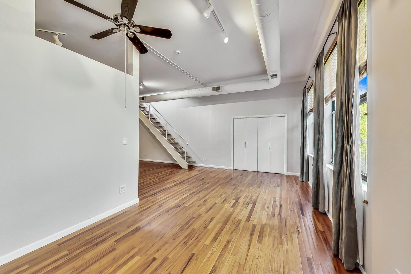400 North Racine Avenue, Unit 217 Chicago, IL 60642 - Photo 13 of 29 a view of a hallway with wooden floor and staircase