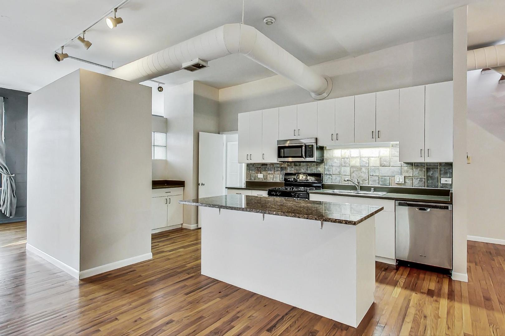 400 North Racine Avenue, Unit 217 Chicago, IL 60642 - Photo 14 of 29 a kitchen with stainless steel appliances white cabinets a sink a stove a refrigerator and microwave