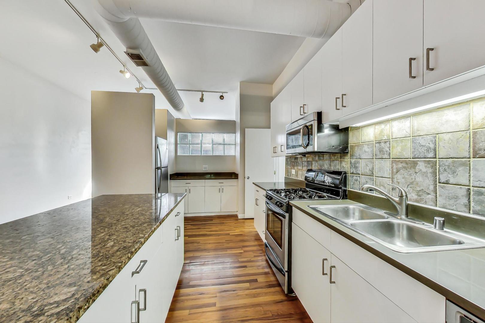 400 North Racine Avenue, Unit 217 Chicago, IL 60642 - Photo 15 of 29 a kitchen with stainless steel appliances granite countertop a sink stove and refrigerator