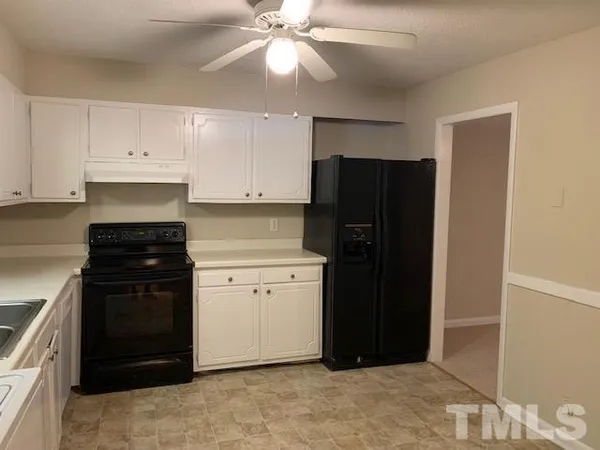 a kitchen with a refrigerator and a stove top oven