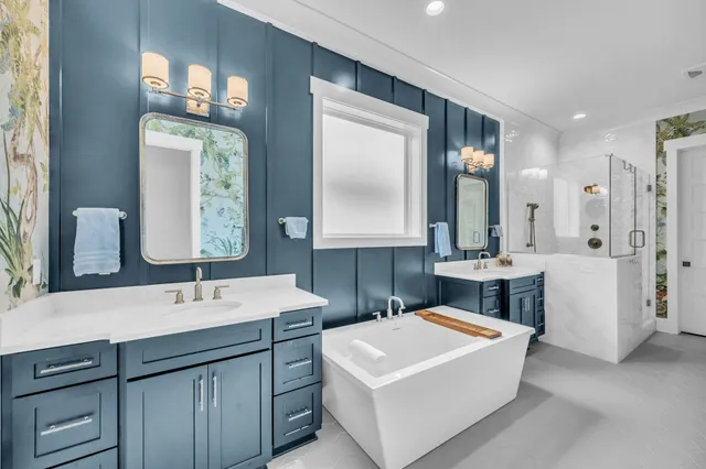 a bathroom with a sink double vanity mirror and a bathtub