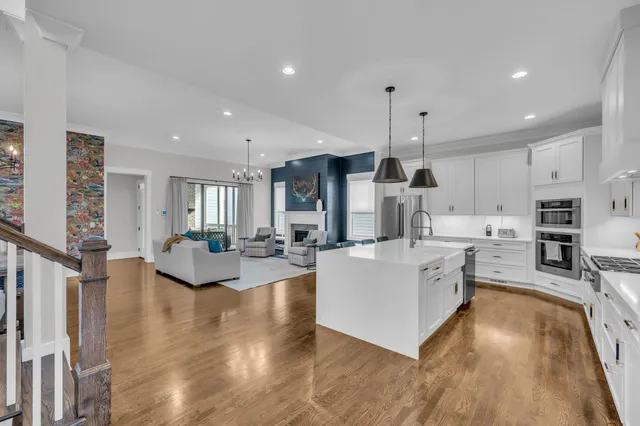 a living room with stainless steel appliances kitchen island granite countertop a couch and a view of kitchen