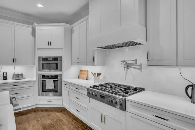 a kitchen with white cabinets and appliances