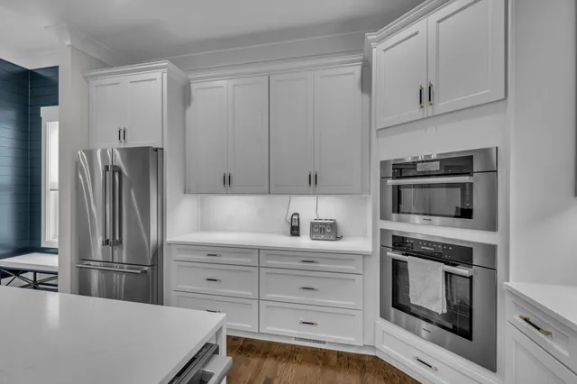 a kitchen with white cabinets and stainless steel appliances