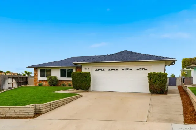a view of house with a yard and garage