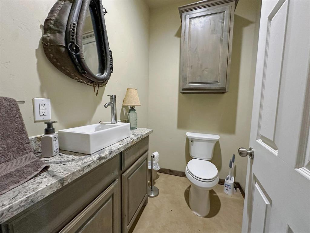 1990 Jim Harry Loop Sunset, TX 76270 - Photo 12 of 39 a bathroom with a granite countertop toilet sink and mirror
