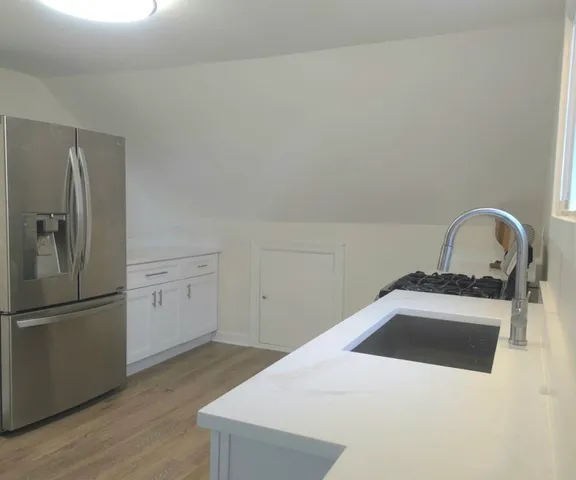 a kitchen with a refrigerator sink and cabinets