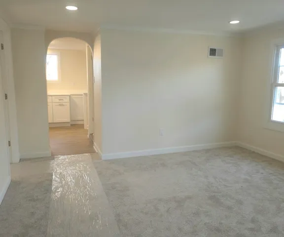an empty room with a window and wooden floor